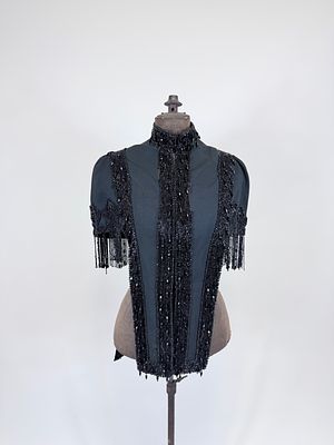 ANTIQUE JET BEADED WOOL CAPELET, 1880s. SH-SH 17", L 13"-26", bead loss, petersham torn, wear 