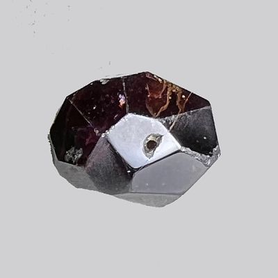 A Dark Amethyst Bead. Late 1st - 2nd millennium CE. 19.6 mm. Multi faceted and perforated. In 