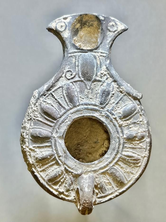 A Jewish Southern-Type Gray Terracotta Oil Lamp. 1st - 2nd century CE. 9.8 cm. Decorated with 