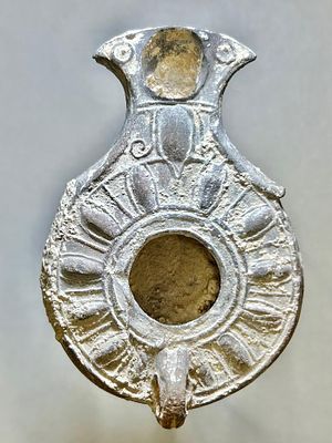 A Jewish Southern-Type Gray Terracotta Oil Lamp. 1st - 2nd century CE. 9.8 cm. Decorated with 