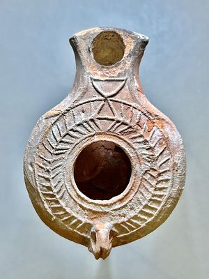 A Jewish Southern-Type Terracotta Oil Lamp. 1st - 2nd century CE. 8.3 cm. Decorated with a 
