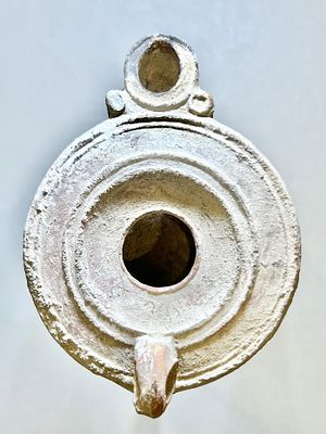 A Jewish Southern-Type Round Terracotta Oil Lamp. 1st - 2nd century CE. 8.9 cm. Decorated with 