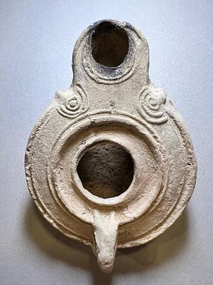 A Jewish Southern-Type Round Terracotta Oil Lamp. 1st - 2nd century CE. 8.4 cm. Decorated with 