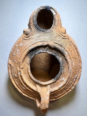 A Jewish Southern-Type Round Terracotta Oil Lamp. 1st - 2nd century CE. 8.4 cm. Decorated with 