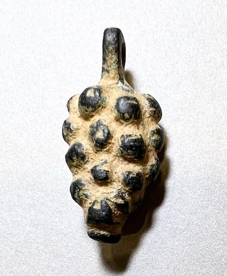 A Bronze Pendant in the form of a Bunch of Grapes. 2nd - 4th century CE. 2.9 cm. In very good 