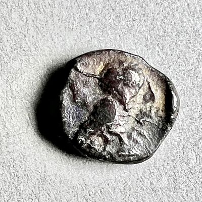 Yehud, 4th century BCE. Silver obol, 0.79 gr; 8.1 mm in diam. Obv: Worn out head of Athena. 