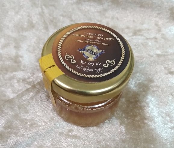 צנצנת דבש קטנטנה (בערך כף דבש) שנתברך על יד האדמו"ר מויזניץ בליל ר"ה תשפ"ה עבור תורמי קופת חיים בחסד