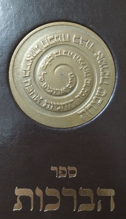 ספר הברכות לשבתות עם מדליה ברונזה בכריכה. הספר מלווה באיורי ותצלומי יודאיקה. מתן אמניות 2006