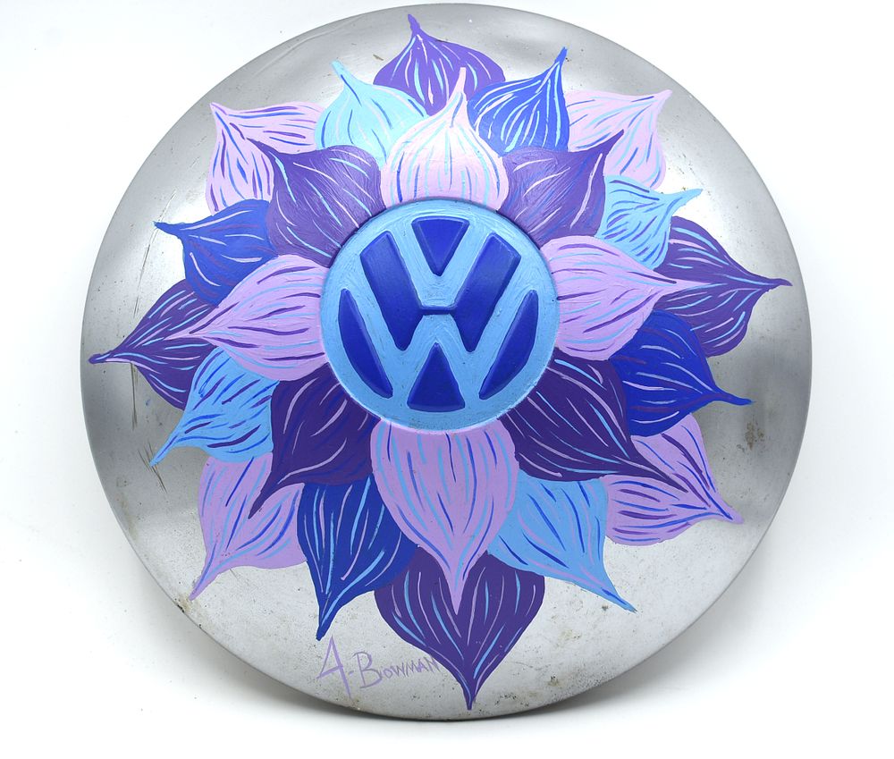 Hand-Painted Volkswagen Hubcap with Blue and Purple Flower Design. A silver hubcap, decorated 