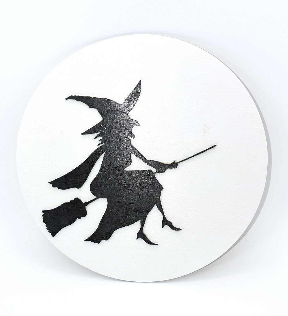Halloween Witch Silhouette Wooden Wall Decor. A single round, white and black Halloween-themed 