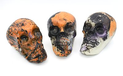 Three Decorative Hydro-Dipped Plastic Skulls. Three decorative skulls, predominantly black 