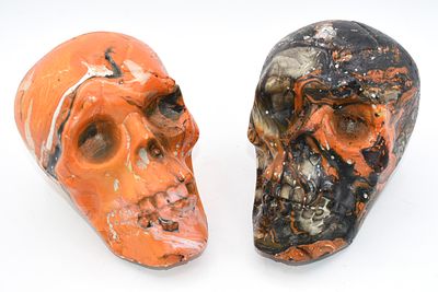Two Orange and Black Swirl Decorative Skull Figures. Two decorative skull figures, one 