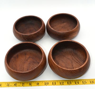 Set of Four Vintage Teak Wood Salad Bowls. A set of four dark brown wooden bowls, likely teak 