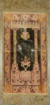 A table top tapestry. A rectangular table top tapestry featuring a dark center with intricate 