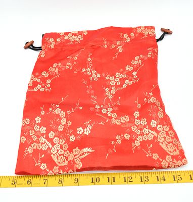 Red Drawstring Bag with Gold Floral Patterns and Wood Beads. A red drawstring bag with gold 