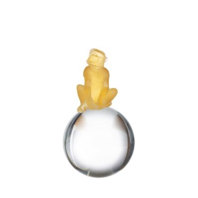 MACACO SENTADO SOBRE ESFERA. Escultura francesa em vidro Daum em tons de amarelo. Marcada "Daum 