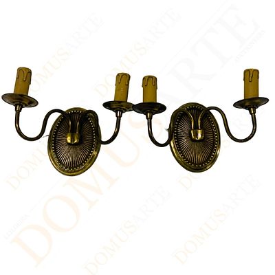 Par de apliques de dois lumes. em metal amarelo, com medalh&atilde;o central oval relevado, de dois 