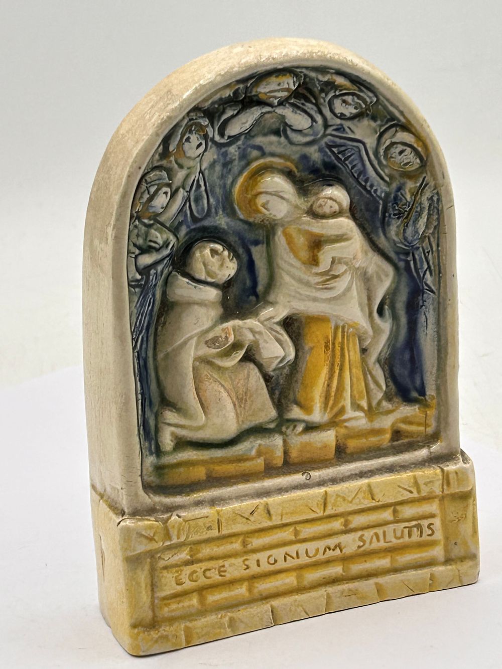Lot 387: A Glazed Ceramic Religious Relief Plaque depicting the Virgin Mary and Christ Child, Marked 'Land of Carmel Aylesford', 5.5” Tall