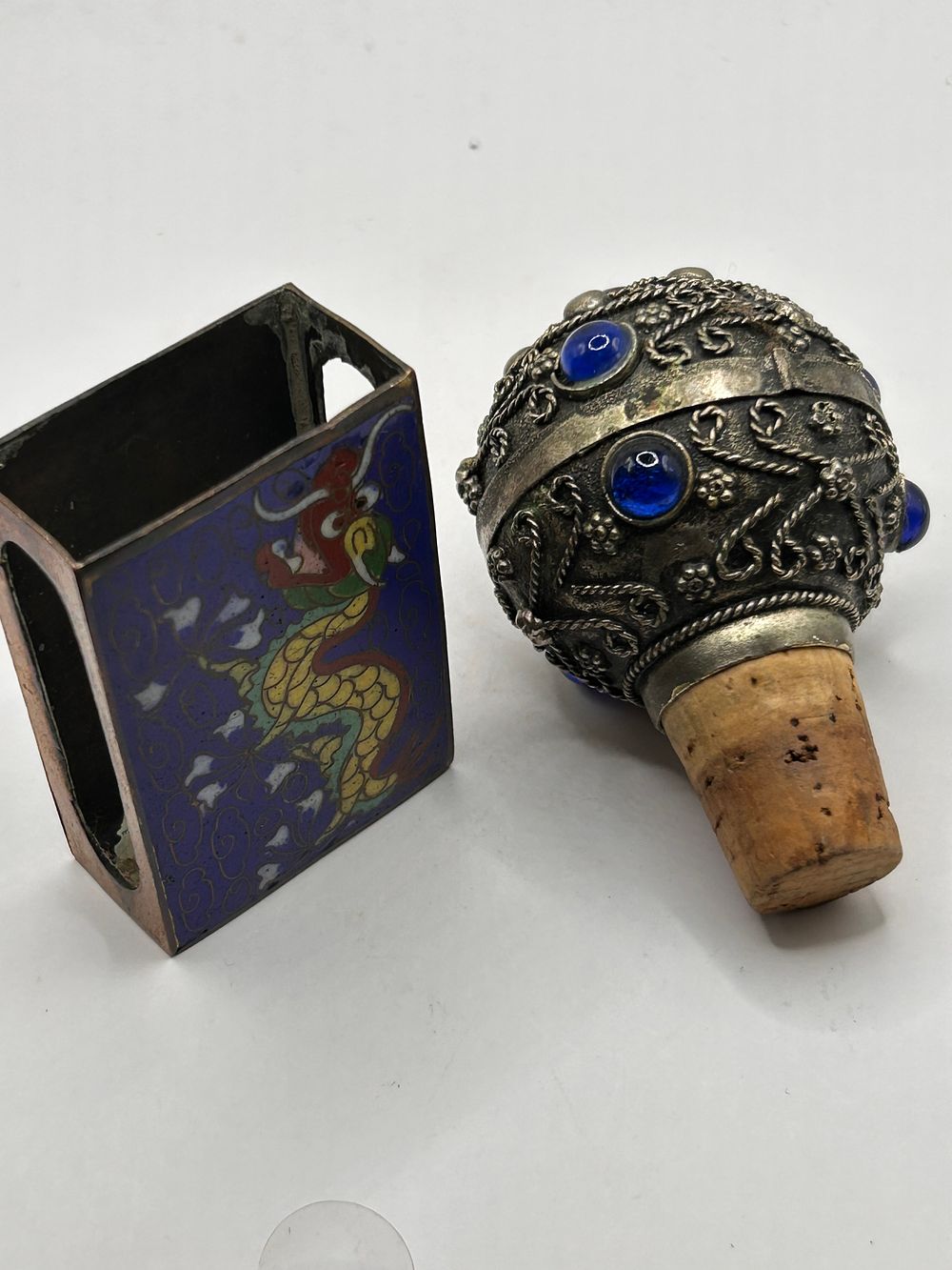 Lot 395: A Cloisonné Enamel Dragon Match Box Holder and an Ornate Silver-Toned Bottle Stopper