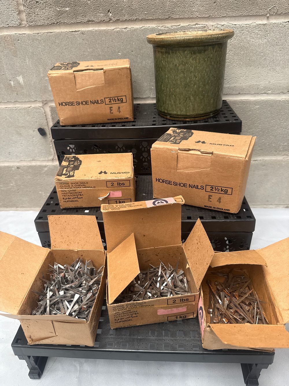 Lot 498: A Group of Mustad Horseshoe Nails and a Green-Glazed Ceramic Pot