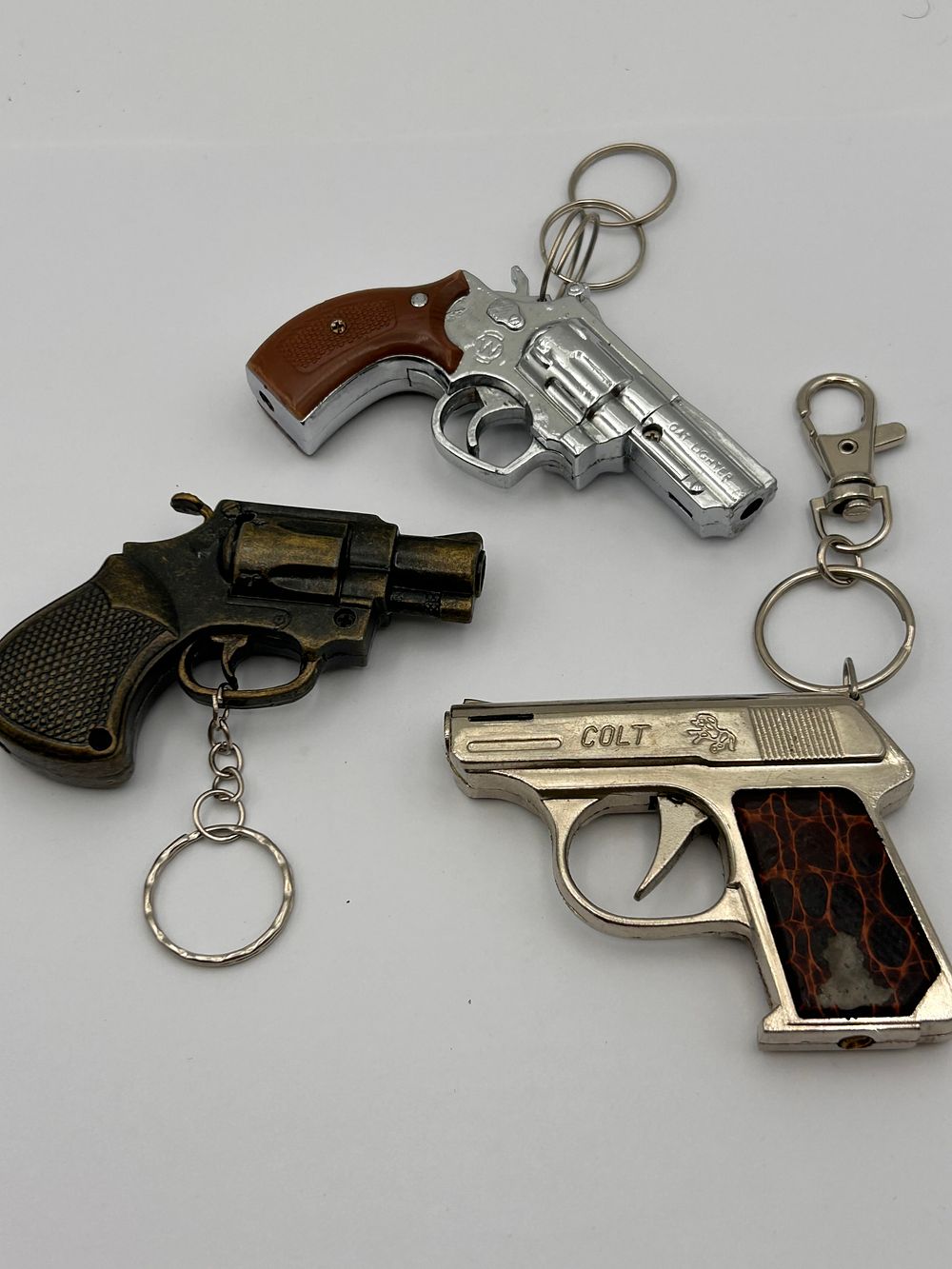 Lot 196: Three Metal Firearm-Shaped Novelty Keychain Lighters