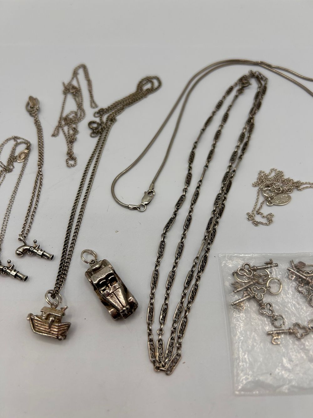 Lot 324: A Collection of Vintage Silver- White Metal Jewelry, including Chains and Charms, one marked 'Sonia'