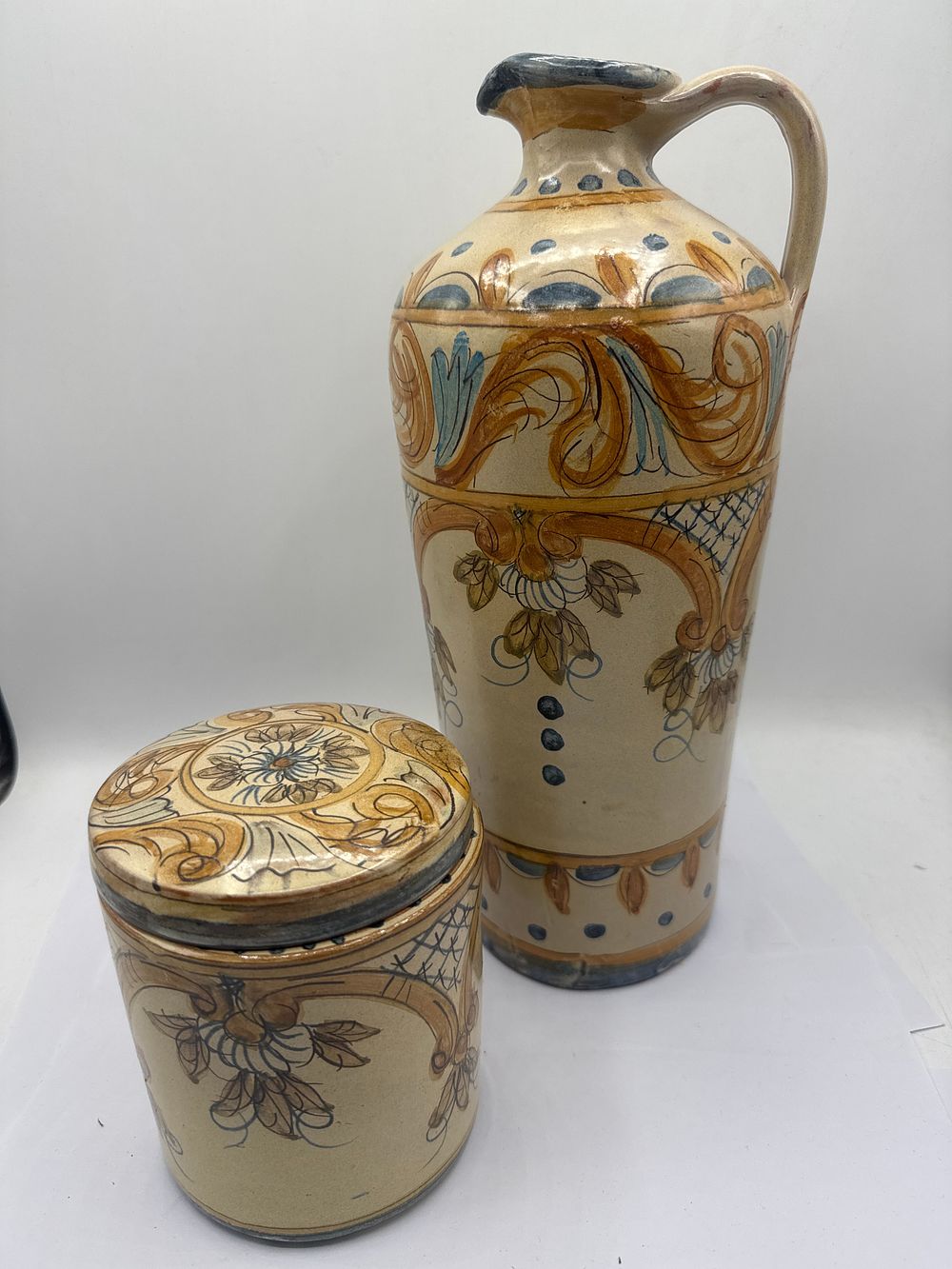 Lot 331: A Pair of Portuguese Glazed Earthenware Vessels from Olaria de Alferragi, Algarve, comprising a pitcher and a lidded jar, the tallest 13 inches