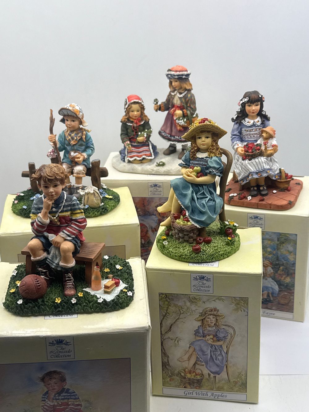 Lot 43: A Collection of Five The Leonardo Collection Figurines by Christine Haworth, including 'Girl With Apples' and 'First Flowers'