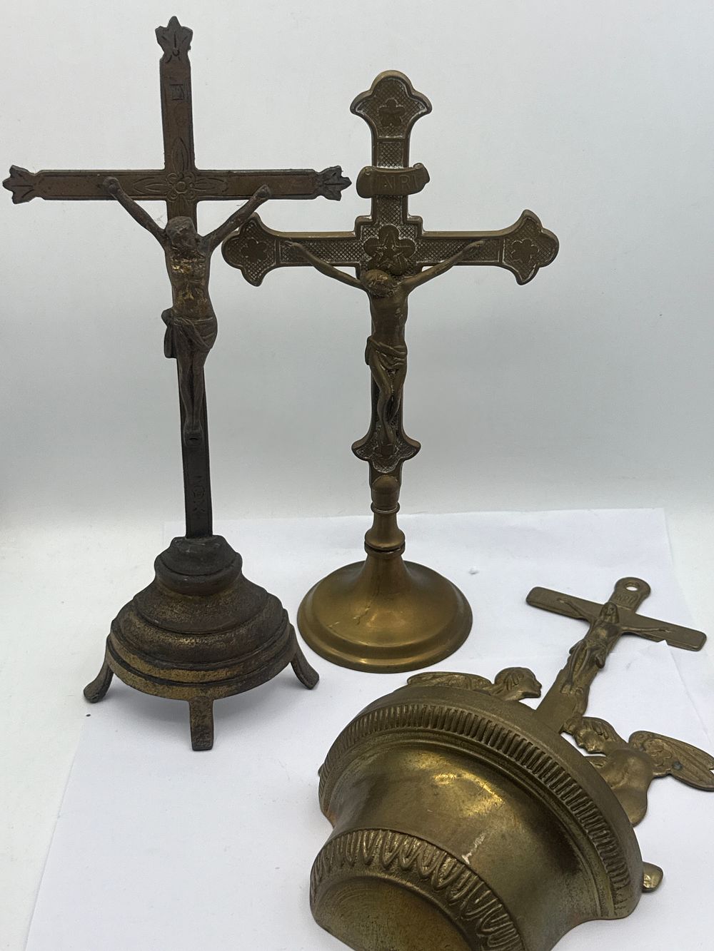 Lot 46: Three Brass or Bronze Religious Devotional Objects, including two Standing Crucifixes, the tallest approximately 13 inches high, and a Holy Water Font