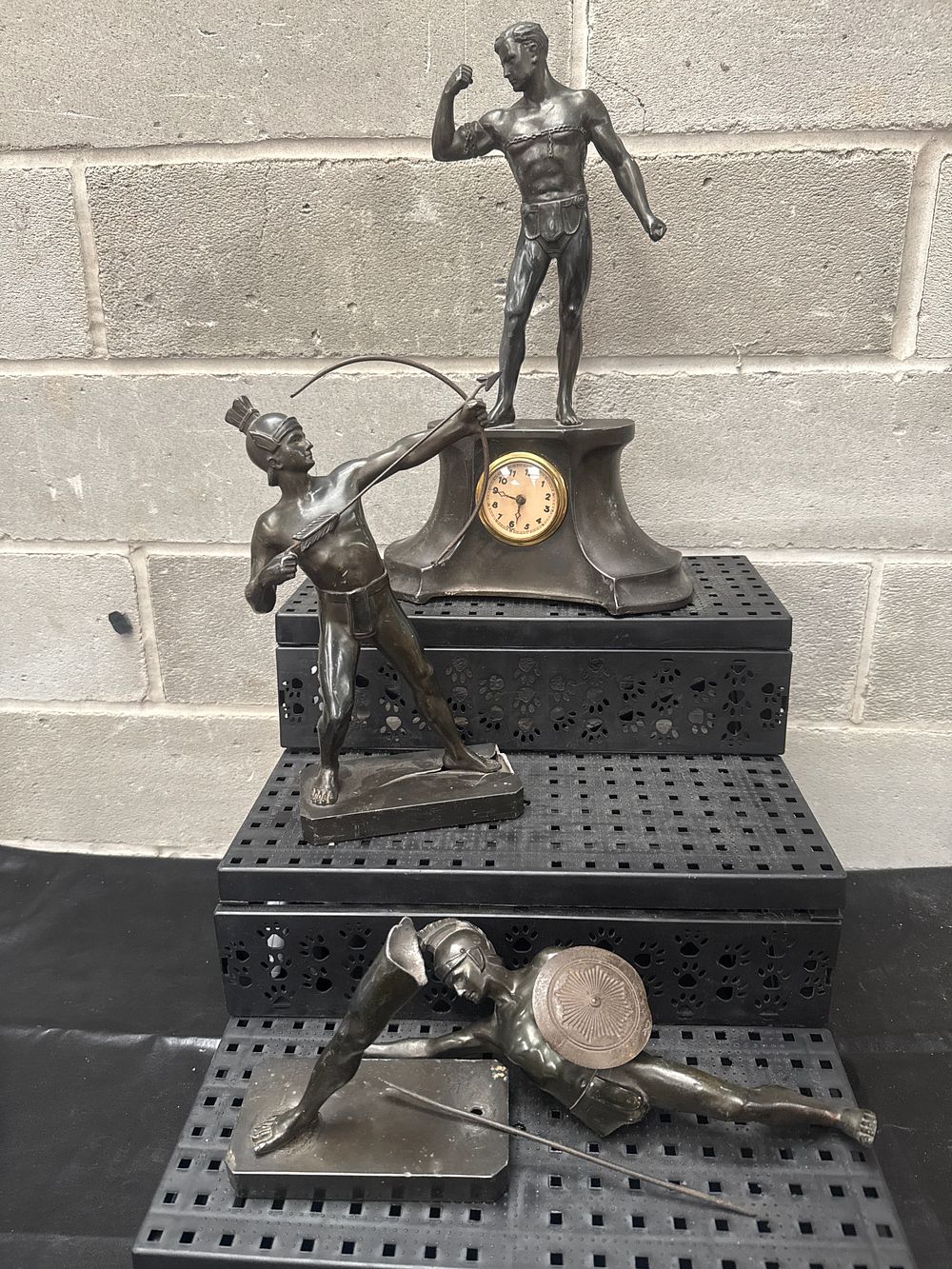 Lot 406: An Ensemble of Three Bronzed Spelter Figures, including a Clock and Two Roman Warriors