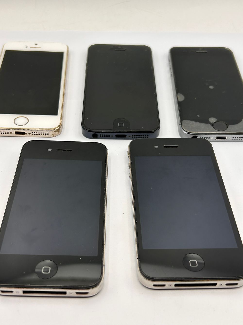 Lot 497: A Group of Five Apple iPhone 4/4S and 5S Series Smartphones.