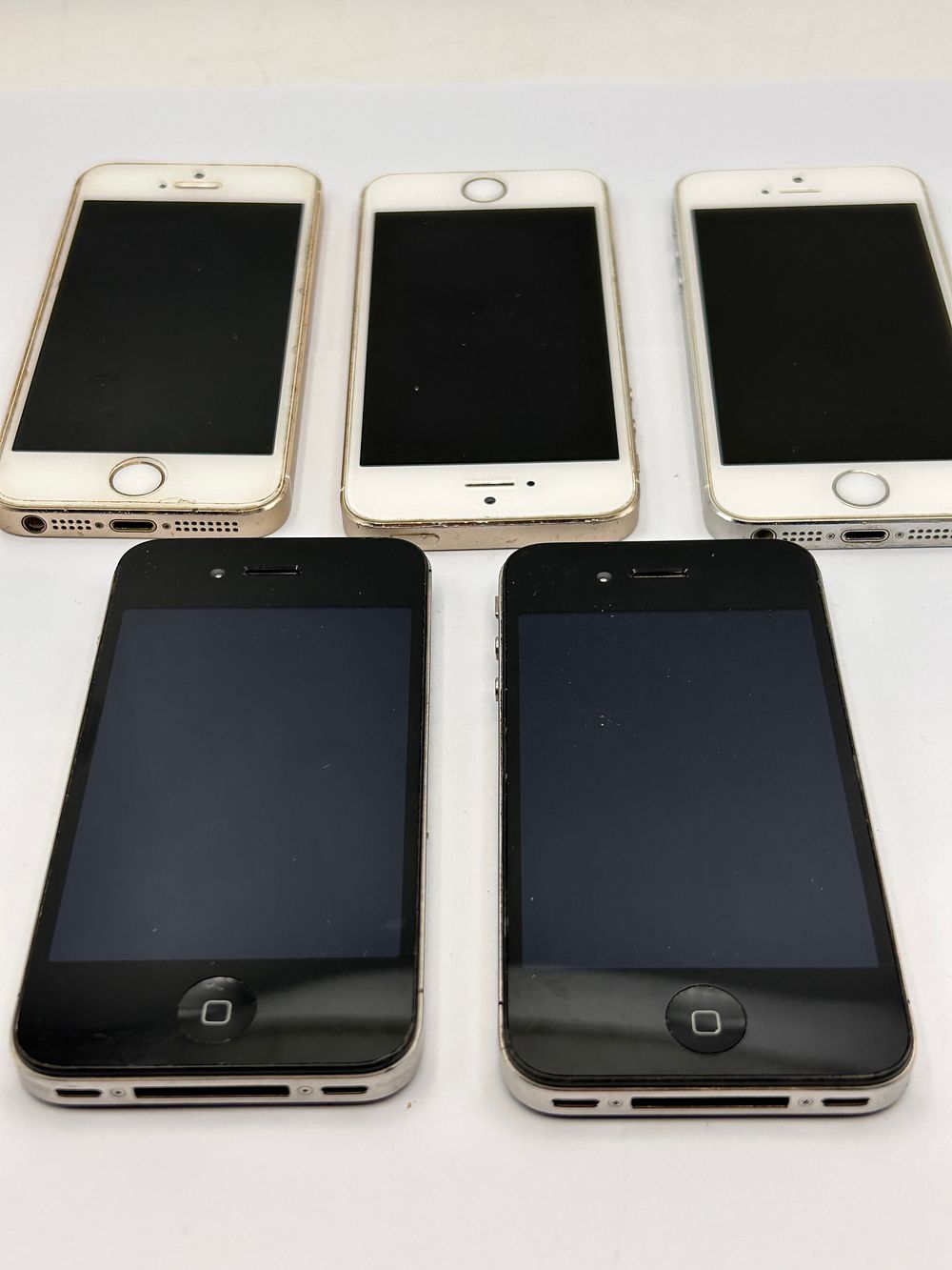 Lot 498: A Group of Five Apple iPhone Smartphones, including iPhone 4, 4S, and 5S models