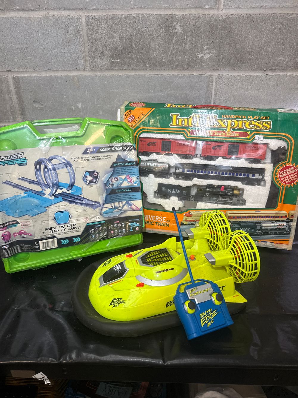 Lot 513: A Collection of Toy Vehicle Sets Including Intl Express Train Set Taiyo Edge R/C Hovercraft and Power Rippers Track Set