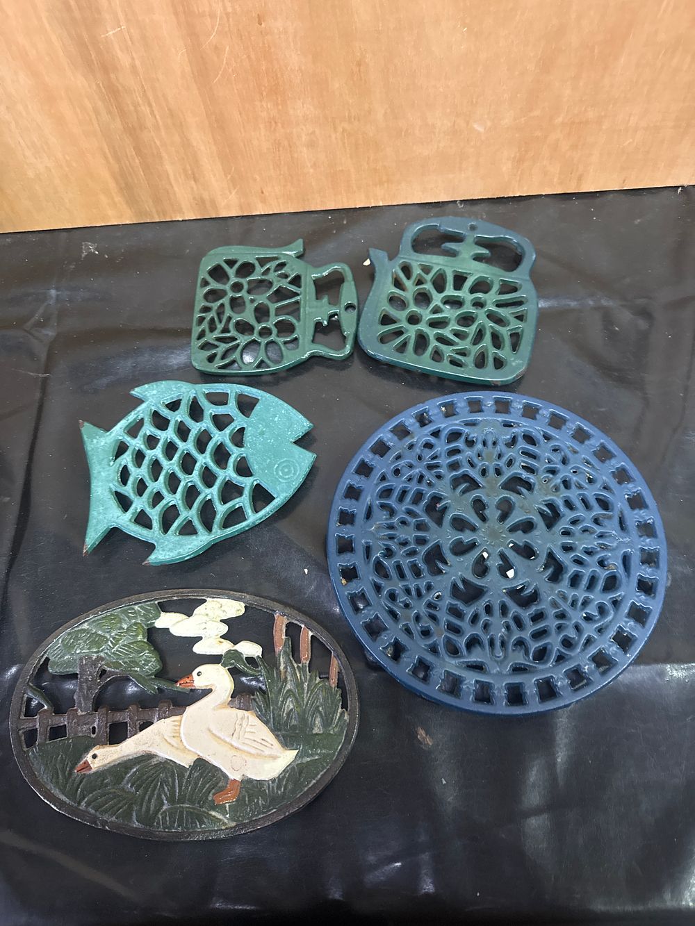 Lot 390: A Collection of Five Enameled Cast Iron Trivets