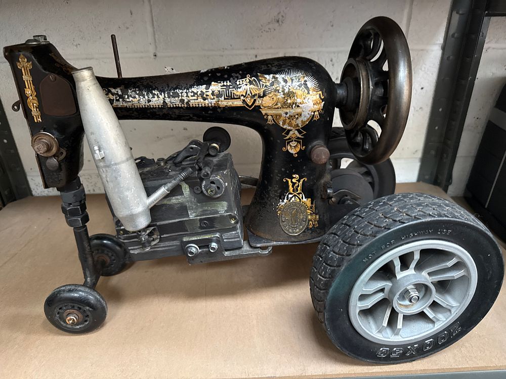 Lot 548: A Steampunk Sculpture of a Tractor Repurposed from a Singer Sphinx Sewing Machine Head
