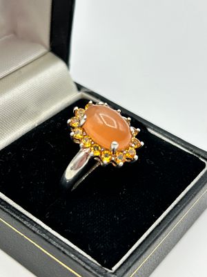 A Sterling Silver Cocktail Ring Featuring an Orange Cabochon and Yellow Stone Halo