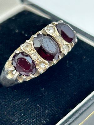 A Victorian style silver garnet and diamond point trilogy ring