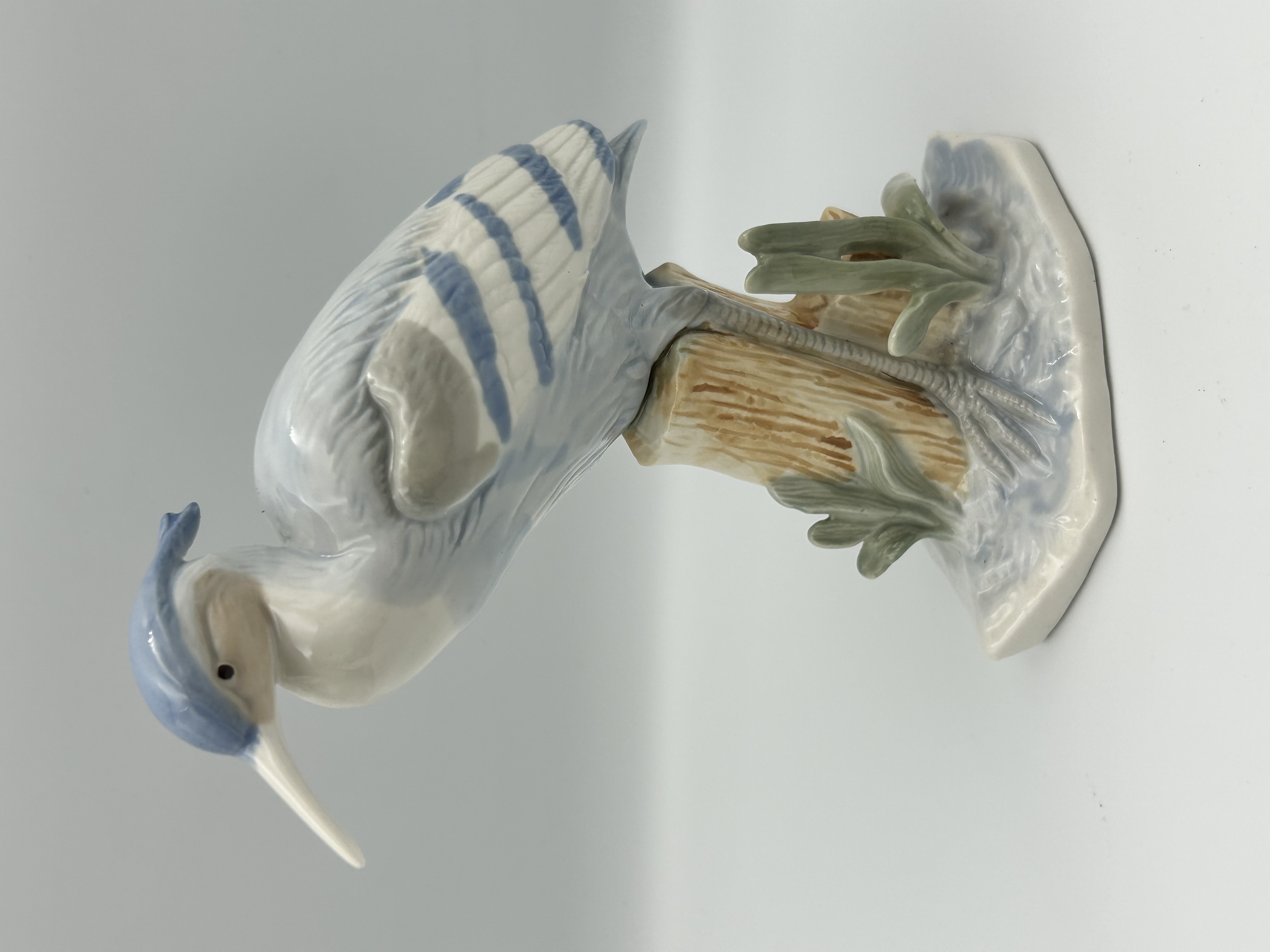 A Glazed Porcelain Figurine of a Heron Perched on a Tree Stump