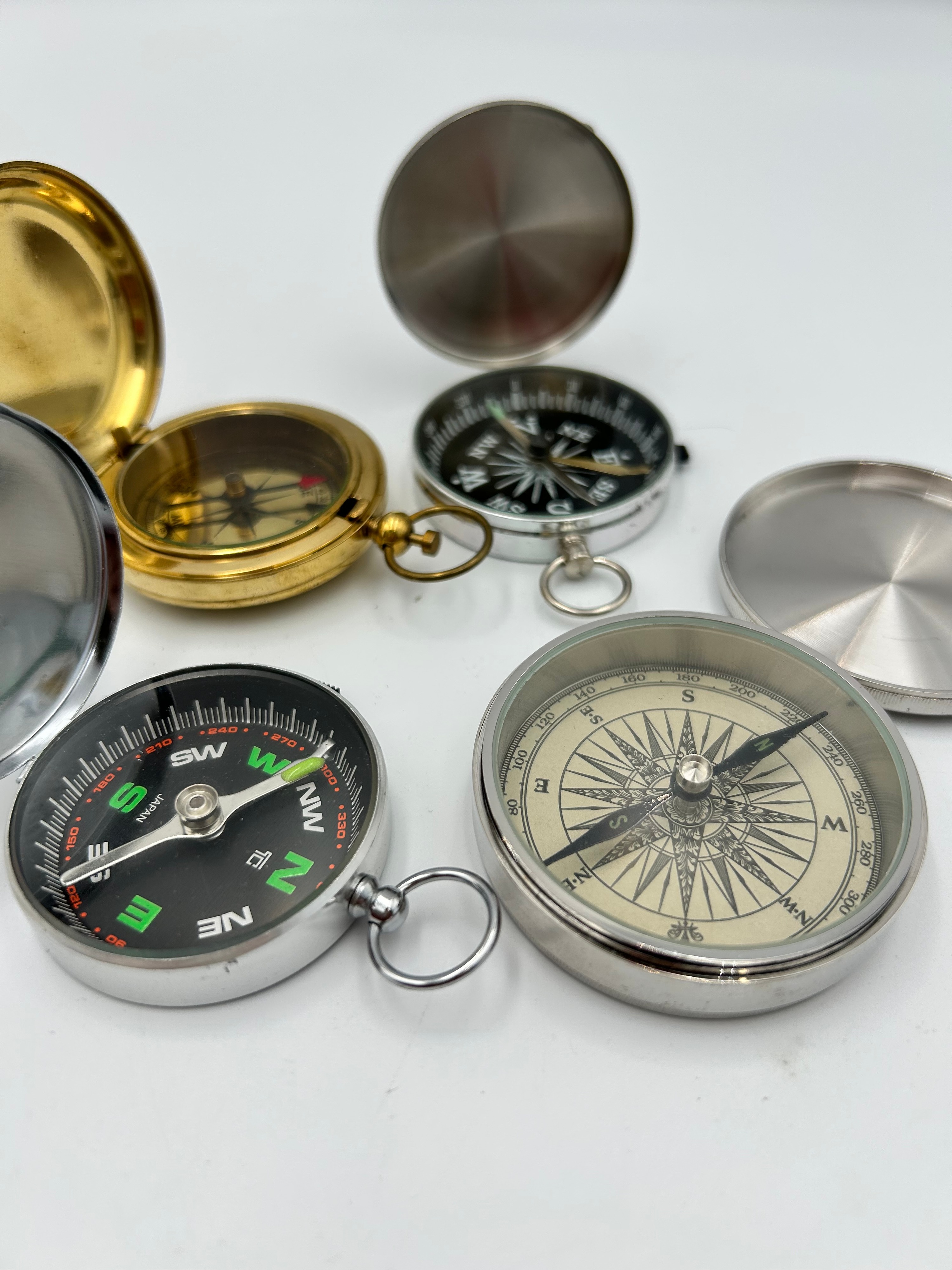 A Collection of White Metal and Brass Effect Nautical Style Pocket and Desk Compasses