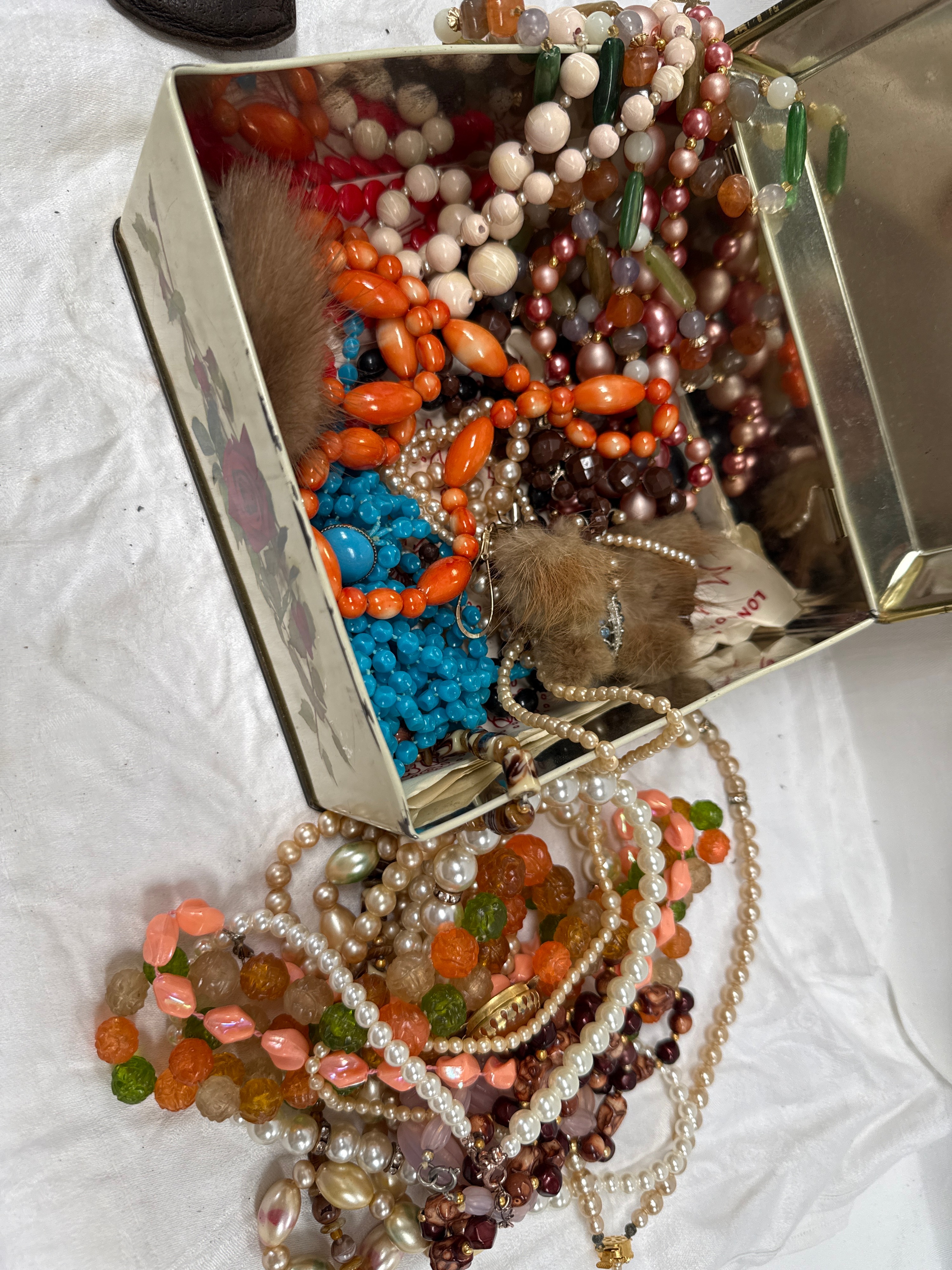 An Assortment of Mid-Century Glass and Plastic Costume Jewellery in a Floral Tin