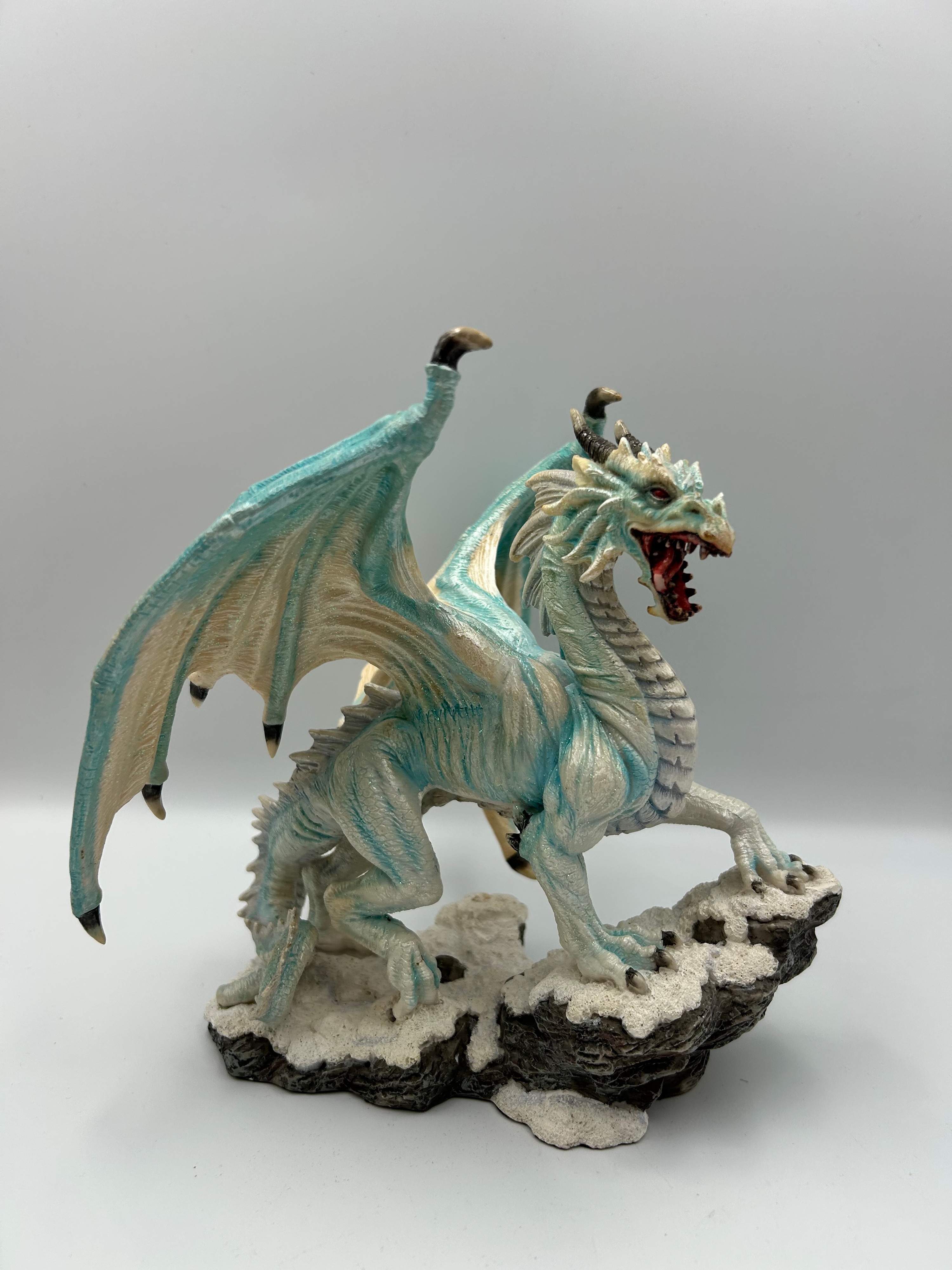 A  Fantasy Ice Dragon Figurine on Snowy Rock Base