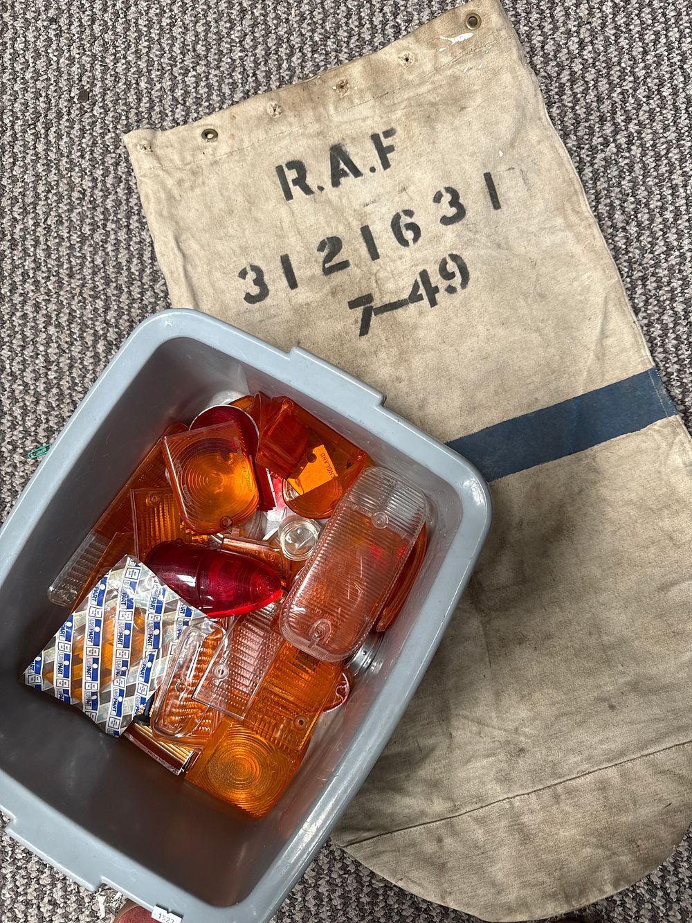 Lot 554: A Collection of Mid-20th Century Plastic Automotive Lenses by Magnatex? and Unipart and an R.A.F. Bag