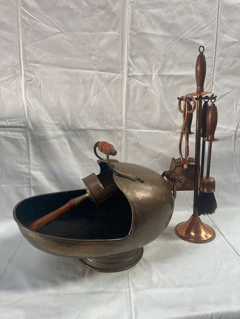 Lot 946: A Mid-20th Century? Brass and Copper-Toned Fireside Collection Including Helmet Scuttle and Companion Set