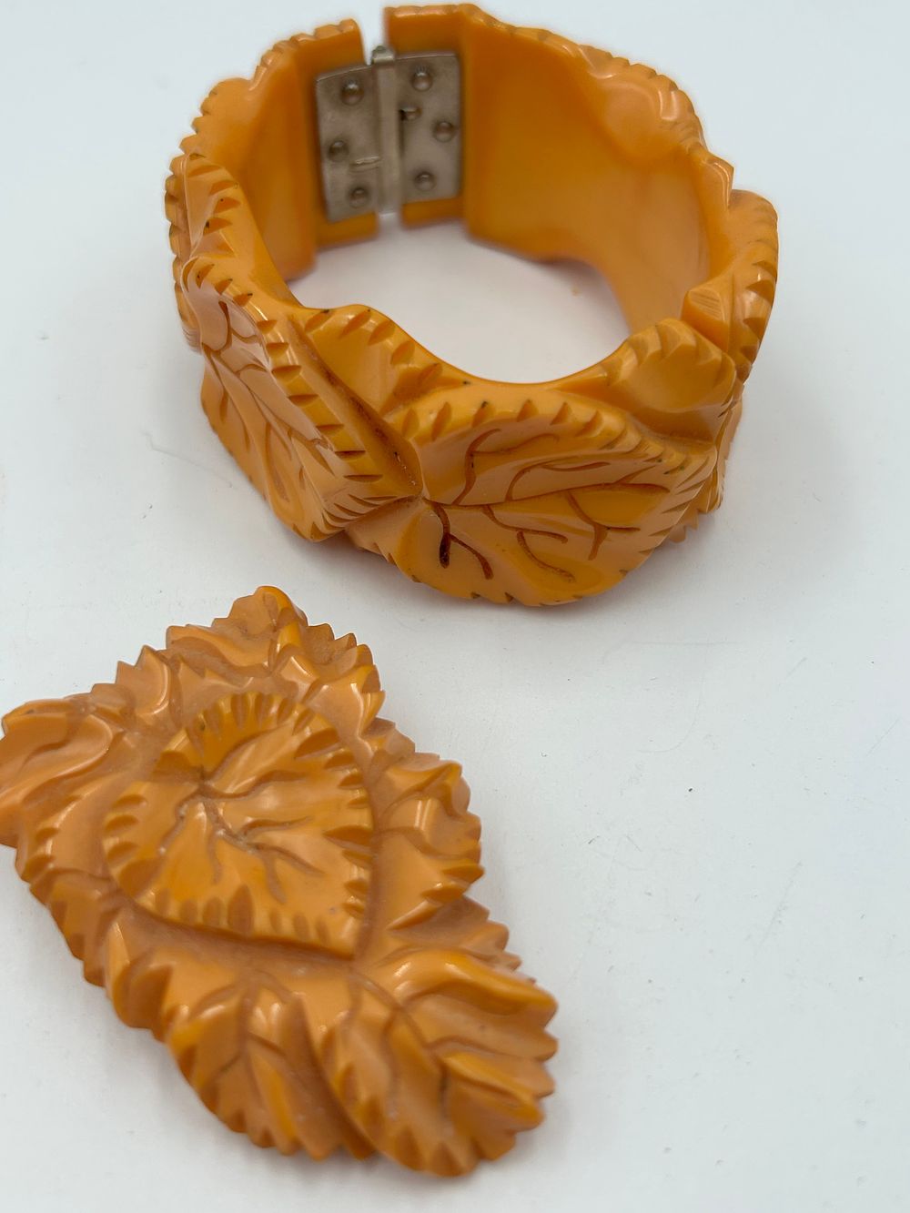 Lot 97: Art Deco Heavily Carved Butterscotch Phenolic Resin? / Bakelite? Clamper Bracelet and Dress Clip
