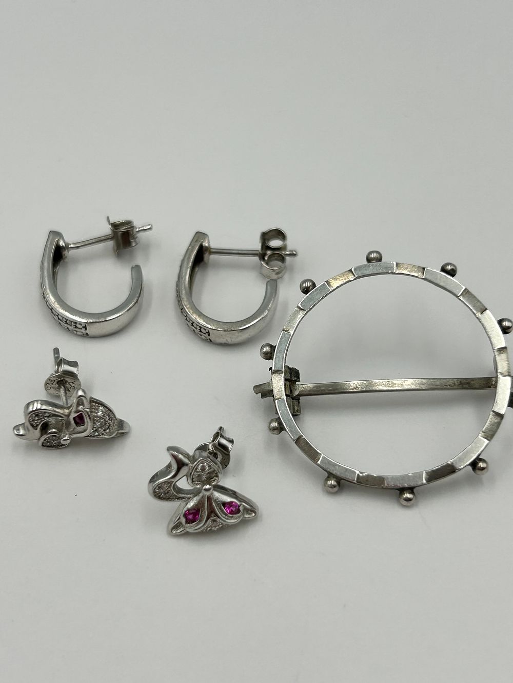Lot 103: A Collection of Sterling Silver Earrings and an Openwork White Metal Brooch, 4.8g