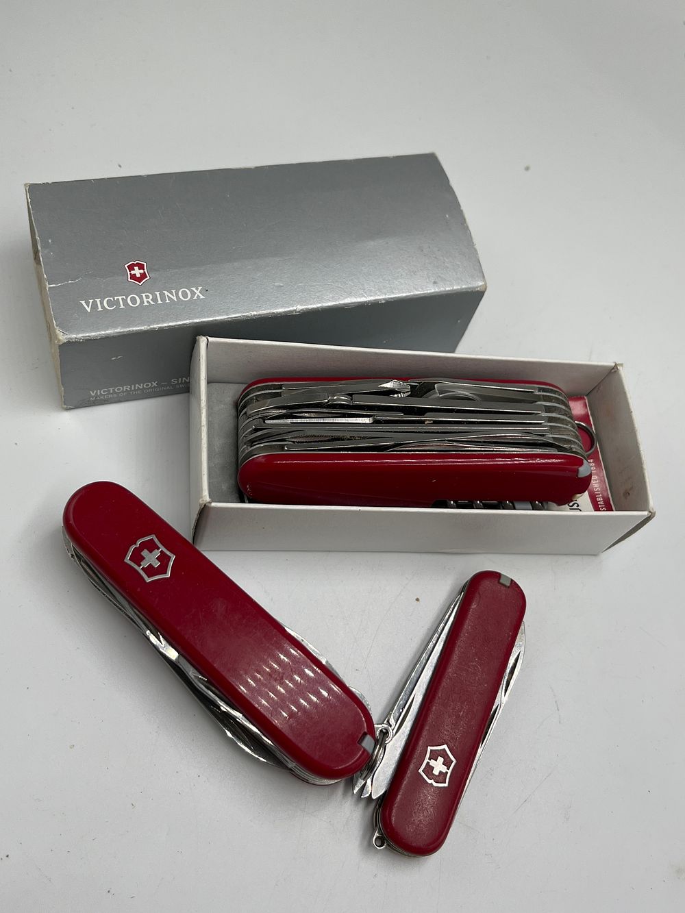 Lot 695: Victorinox SwissChamp and Assorted Red Cellidor Multi-Tool Pocket Knives