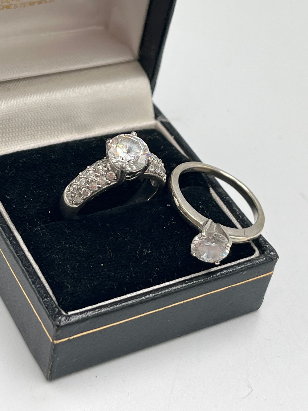 Lot 735: A Pair of Sterling Silver Rings Set with Colorless Stones