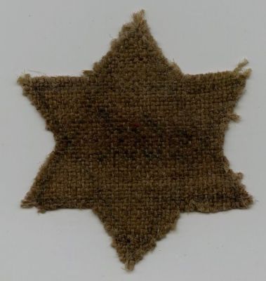 טלאי צהוב של הנער אדם הולנדר שנירצח בשואה בהיותו נער. טלאי צהוב של יהודי בשם אדם הולנדר שנירצח 