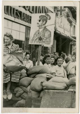 תצלום מפגינים צרפתים מחזיקים שלט עליו נראה היטלר בטלאי צהוב. תצלום מפגינים צרפתים ליד ביצור 