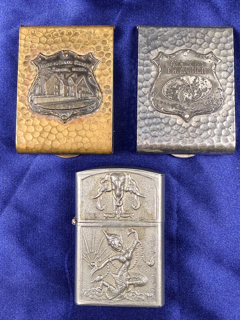 Lot 65: A Trio of Vintage Metal Tobacciana Items Including Souvenir Matchbook Covers and Siam Style Repouss?
